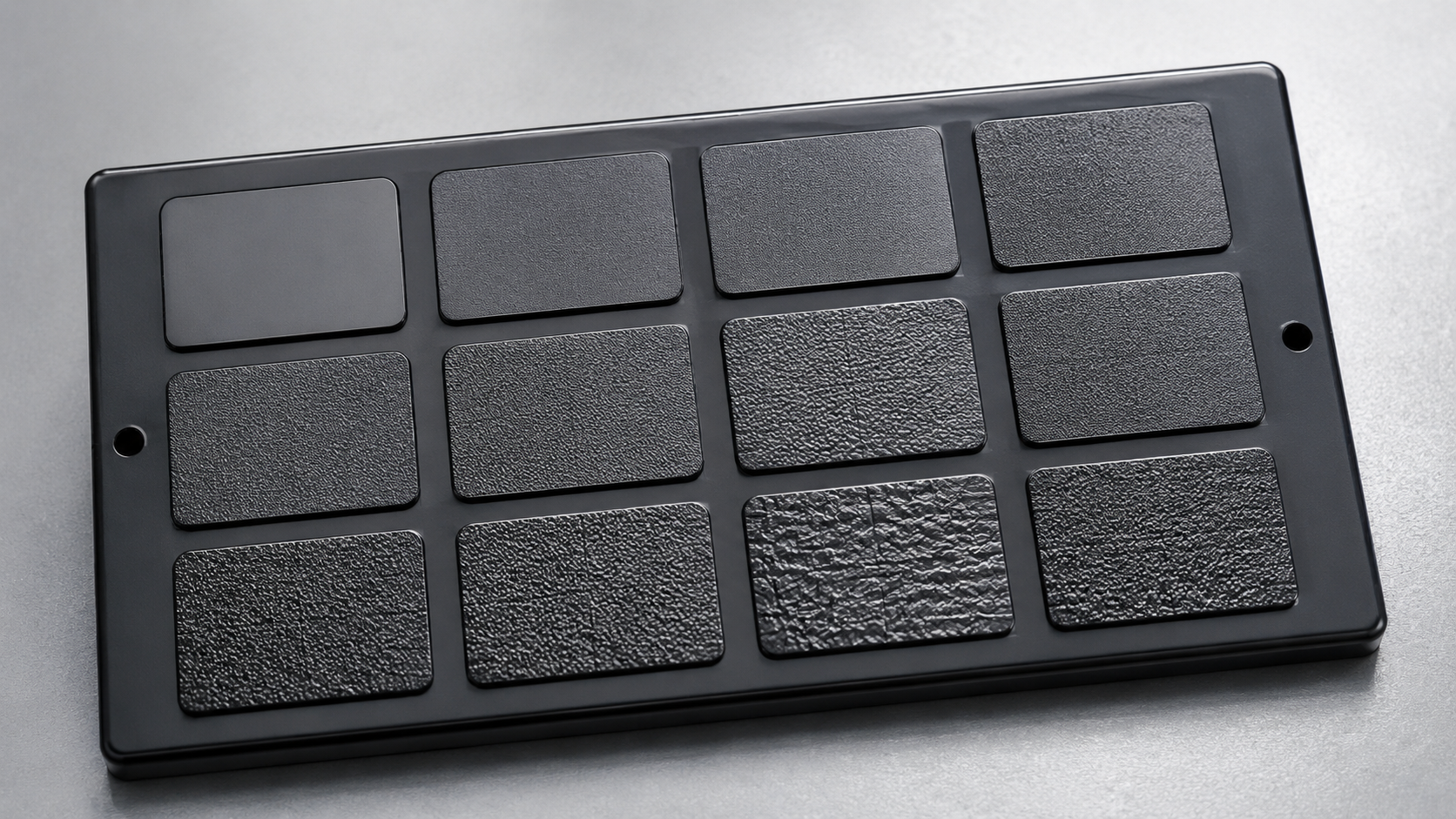 A VDI 3400 texture sample plaque showing EDM spark-erosion finishes ranging from mirror-polished to heavily textured, used to specify mold cavity surface texture